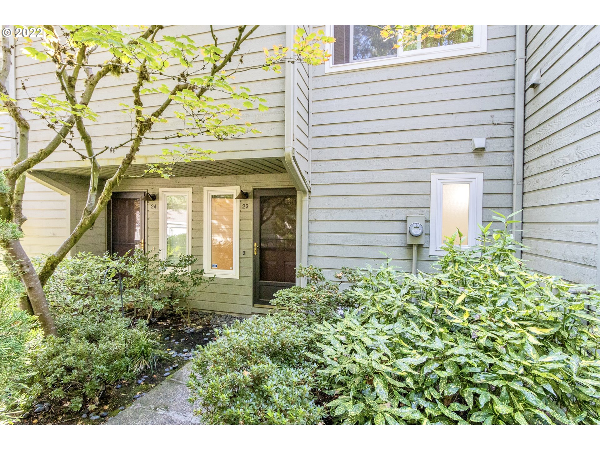4880 Southwest Scholls Ferry Road, Unit 23 Portland, OR 97225 - Photo 1 of 17 a front view of a house with a yard and garage