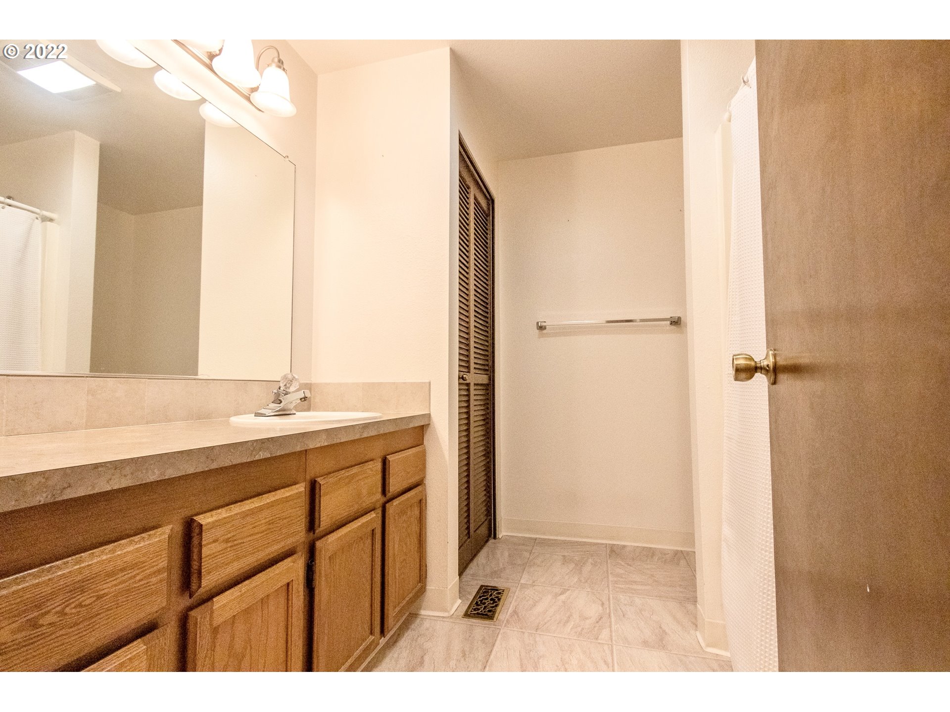 4880 Southwest Scholls Ferry Road, Unit 23 Portland, OR 97225 - Photo 11 of 17 a bathroom with a double vanity sink and mirror