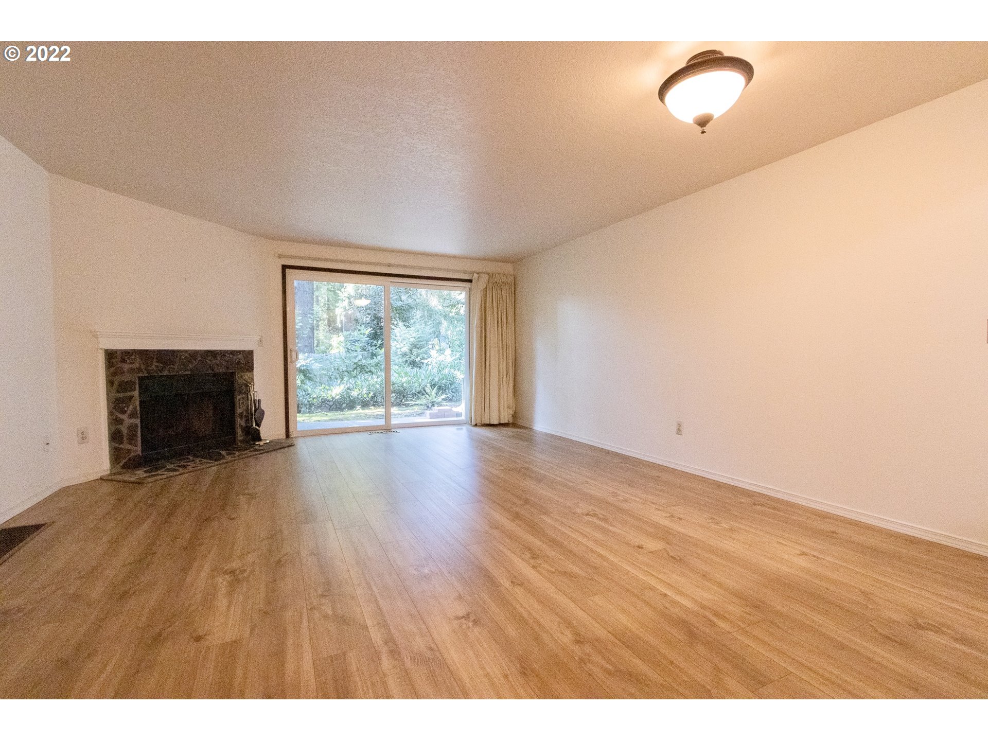 4880 Southwest Scholls Ferry Road, Unit 23 Portland, OR 97225 - Photo 4 of 17 a view of an empty room with wooden floor and a window