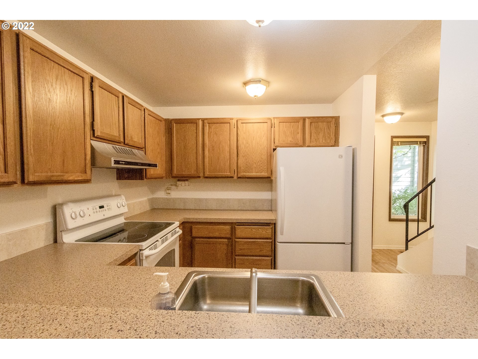 4880 Southwest Scholls Ferry Road, Unit 23 Portland, OR 97225 - Photo 6 of 17 a kitchen with stainless steel appliances granite countertop a sink refrigerator and cabinets