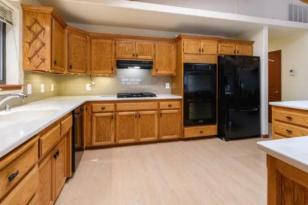 a kitchen with stainless steel appliances granite countertop a refrigerator and a sink