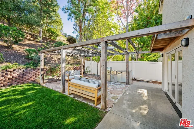 a view of a patio with a table and chairs in front of a house