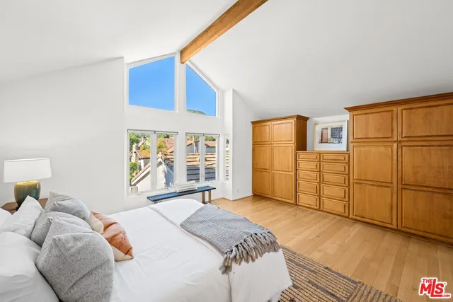 a living room with furniture and a large mirror next to a window