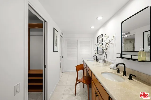 a bathroom with double vanity sinks a shower and a mirror