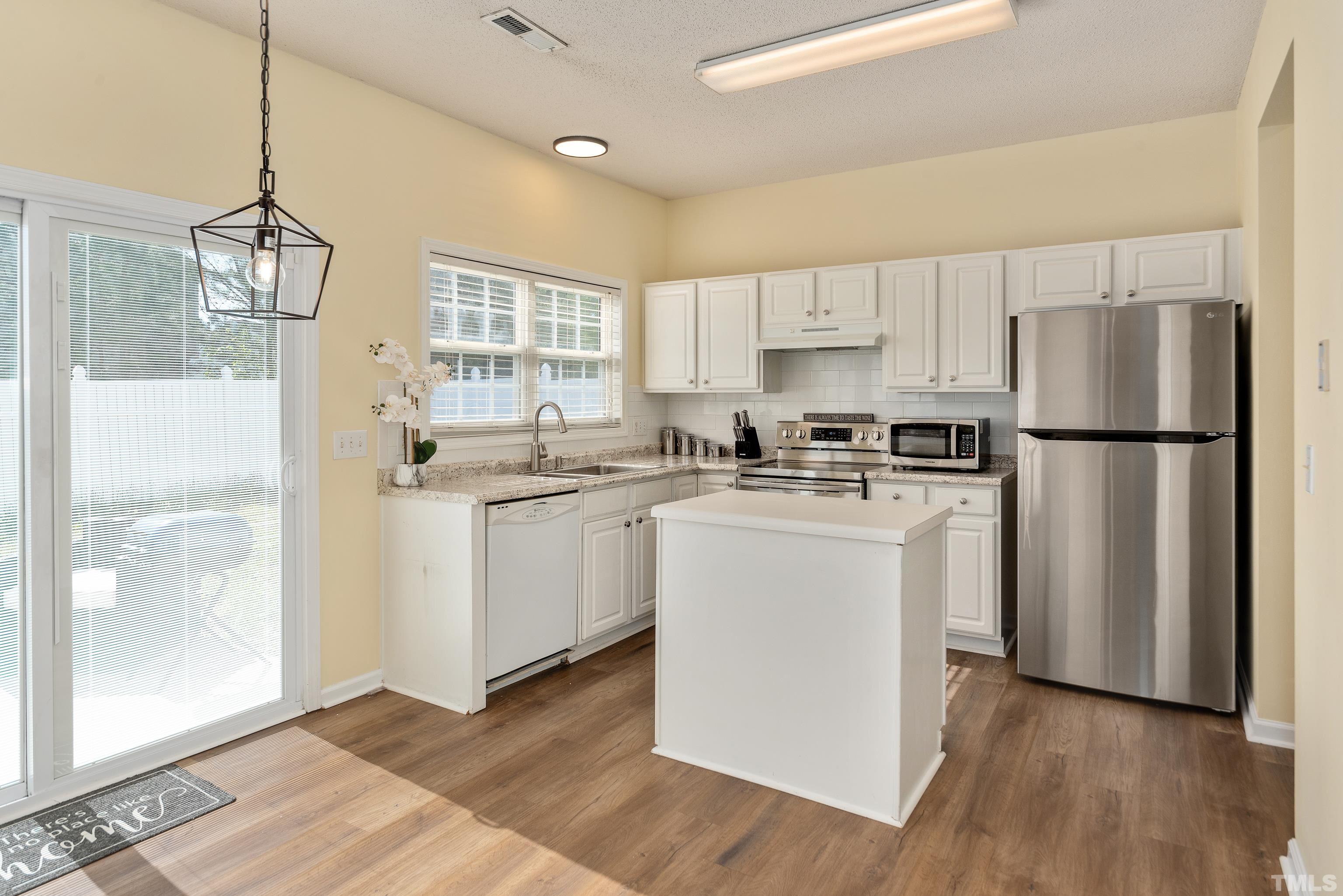 2901 Ranburne Drive Raleigh, NC 27610 - Photo 12 of 29 a kitchen with white cabinets and white appliances