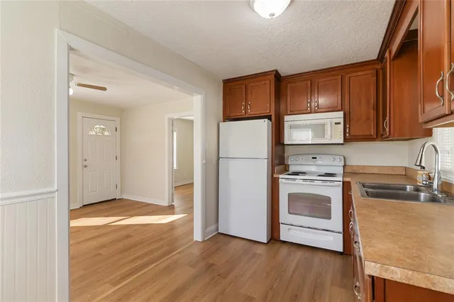 a kitchen with granite countertop a refrigerator and a stove top oven