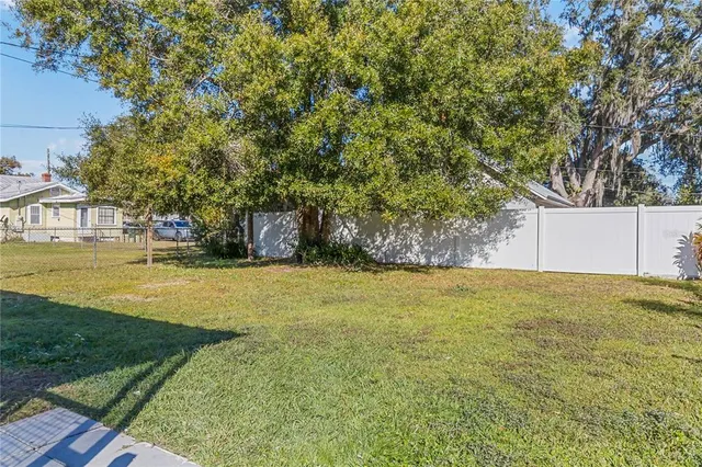 a view of an house with pool and a yard