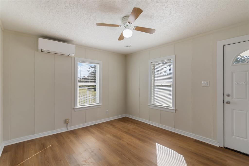 712 4th Street St. Cloud, FL 34769 - Photo 7 of 30 an empty room with wooden floor ceiling fan and windows