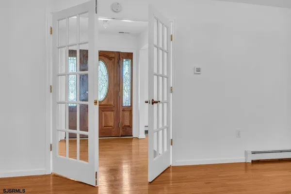 an empty room with wooden floor fireplace and windows