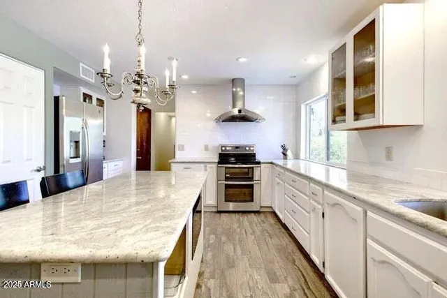 a large kitchen with granite countertop lots of counter space sink and appliances