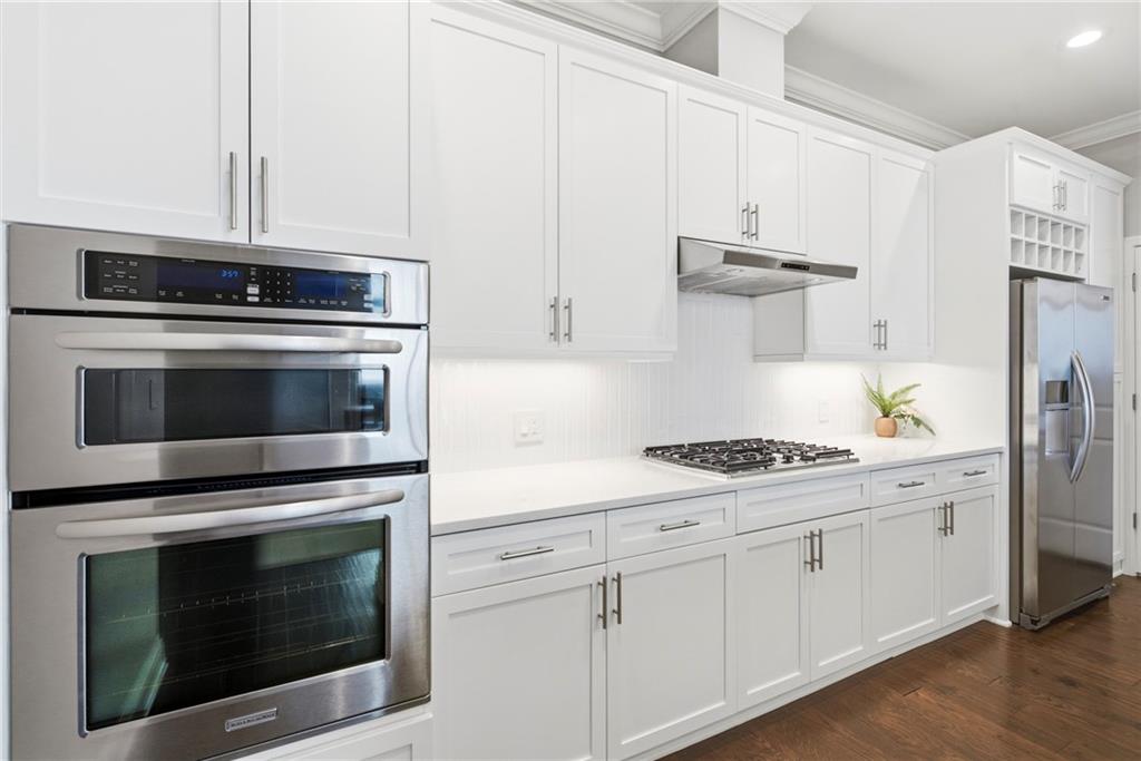 270 17th Street Northwest, Unit 4306 Atlanta, GA 30363 - Photo 4 of 37 a kitchen with stainless steel appliances white cabinets and a stove a oven with wooden floors