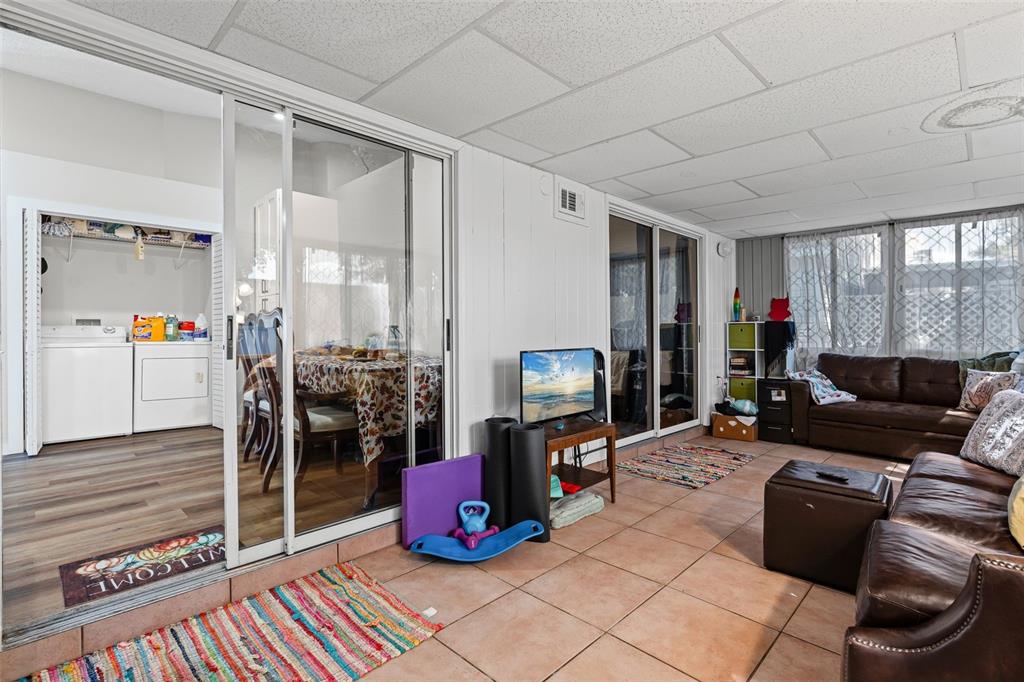 3721 43rd Avenue West Bradenton, FL 34205 - Photo 14 of 26 a living room with furniture a flat screen tv and gym equipment