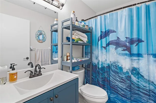 a bathroom with a sink a toilet and shower curtain
