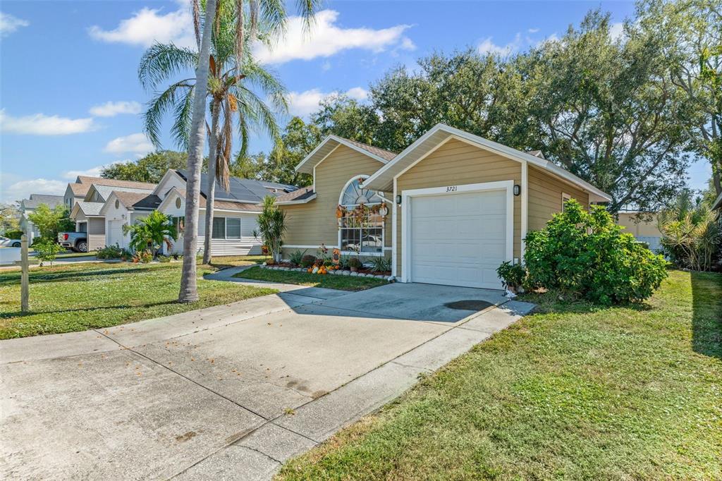 3721 43rd Avenue West Bradenton, FL 34205 - Photo 26 of 26 a view of a white house next to a yard with big trees