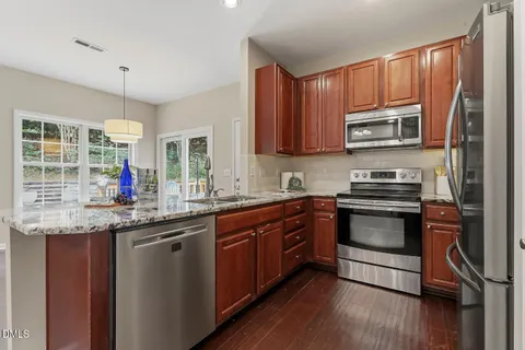 a kitchen with stainless steel appliances granite countertop a stove a sink and a microwave