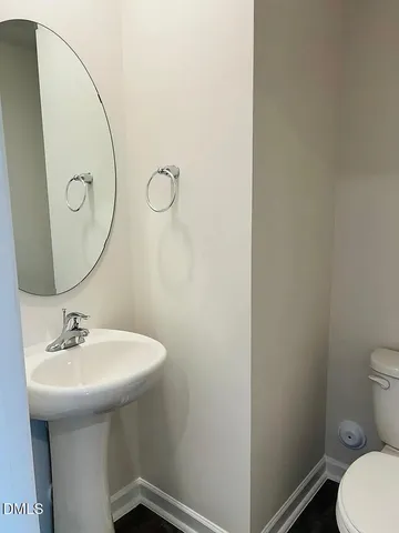 a bathroom with a sink toilet and a mirror