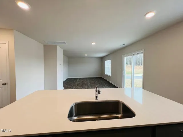 a kitchen with a sink and a large mirror with cabinets