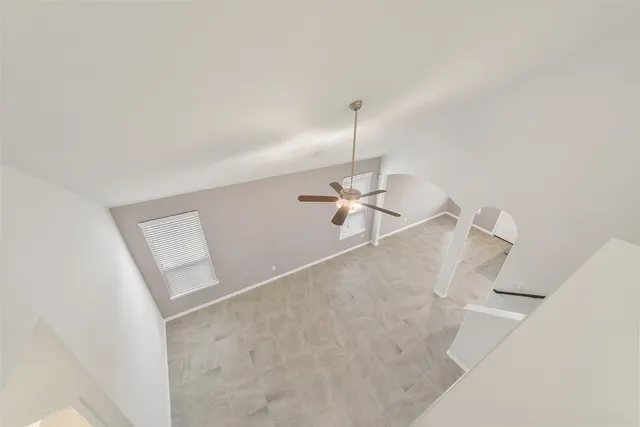 a view of a room with a ceiling fan and wooden floor