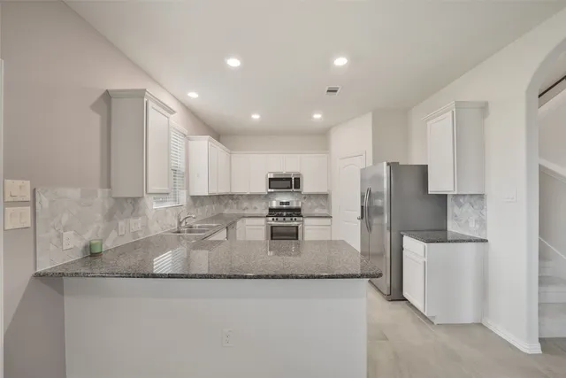 a kitchen with refrigerator and microwave