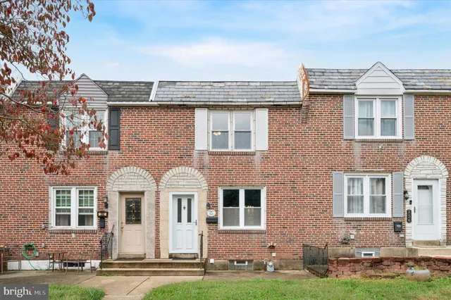 front view of a brick house with a yard