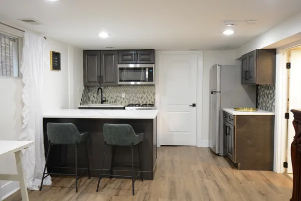 a kitchen with a wooden floor and chairs