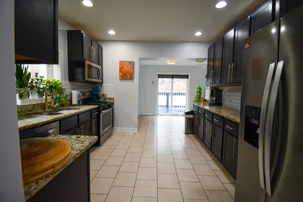 a kitchen with stainless steel appliances granite countertop a refrigerator and a sink