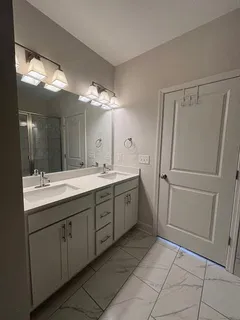 a spacious bathroom with a double vanity sink and a mirror