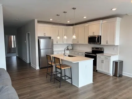 a kitchen with a sink a microwave a refrigerator and cabinets