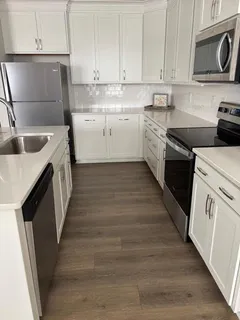 a kitchen with granite countertop a sink a stove and cabinets