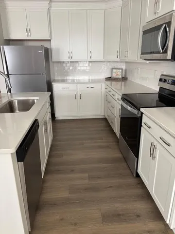 a kitchen with granite countertop a sink a stove and cabinets