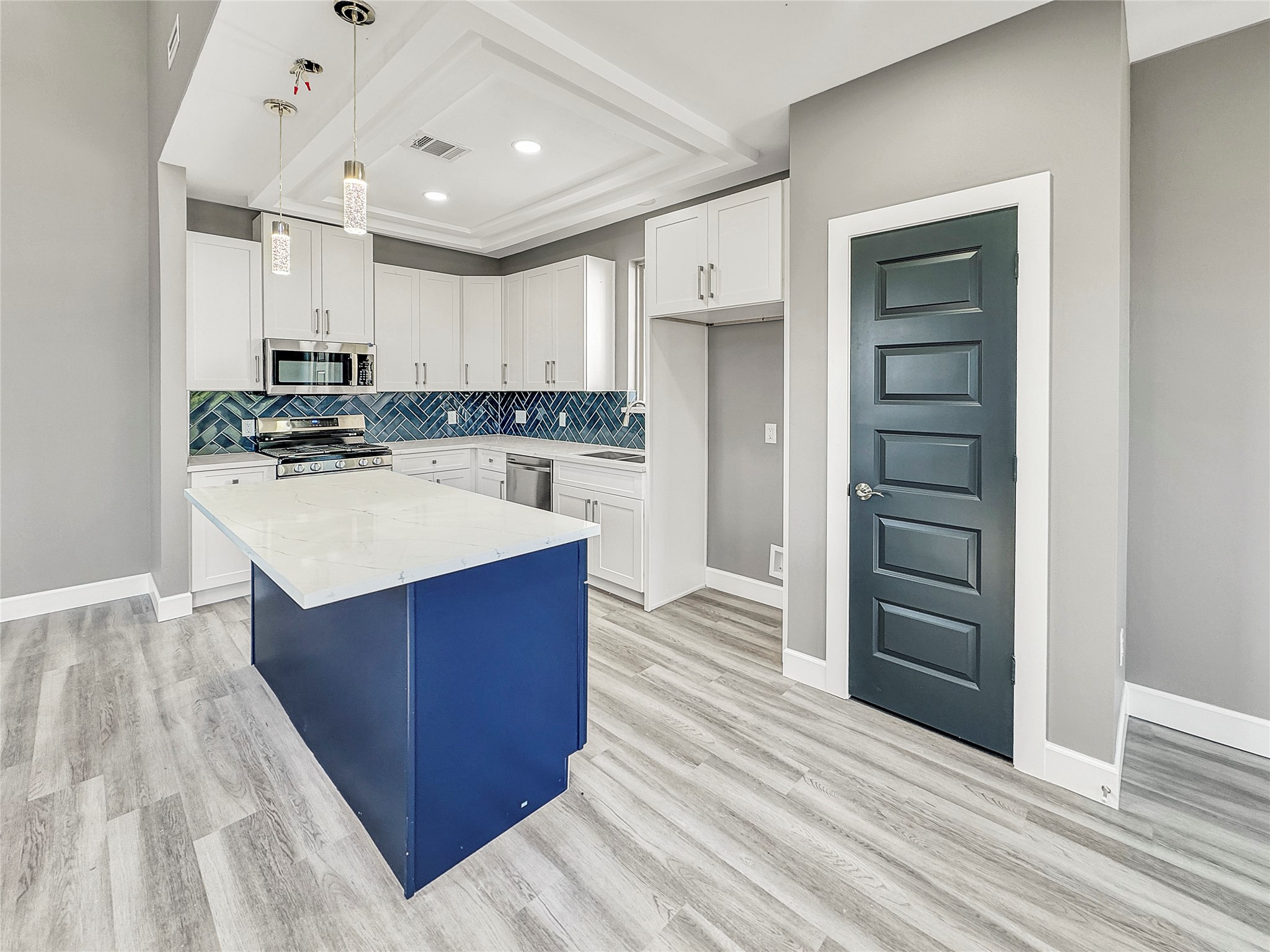 4817 Los Angeles Street Houston, TX 77026 - Photo 5 of 20 a kitchen with wooden floors and white cabinets