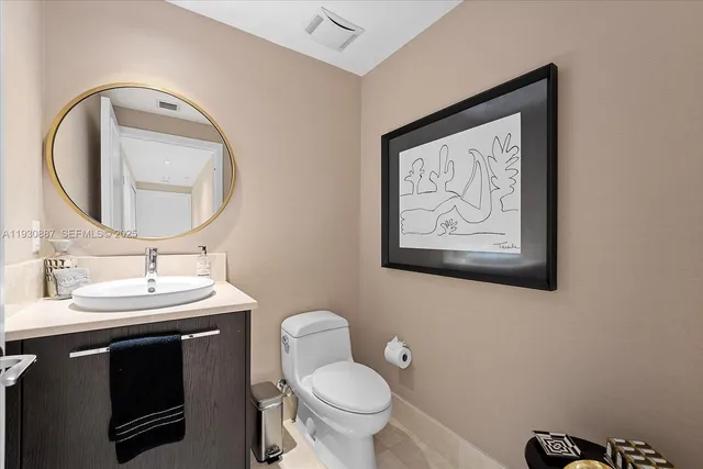 a bathroom with a toilet a sink and a mirror