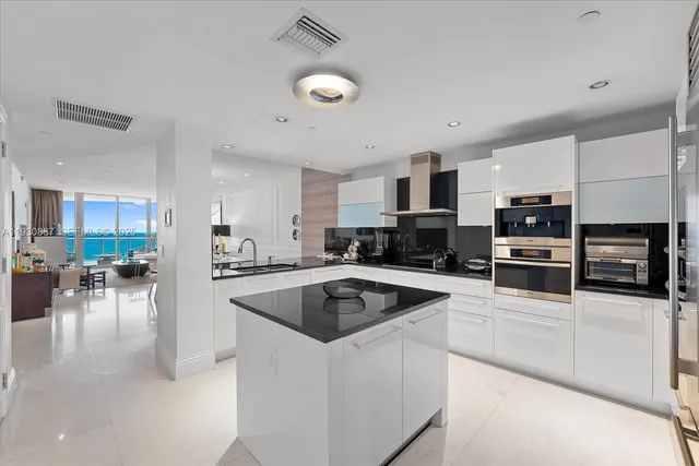 a kitchen with stainless steel appliances a stove a sink a microwave and a refrigerator