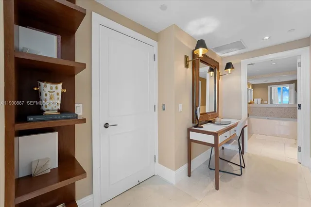 a view of a hallway with furniture and a potted plant