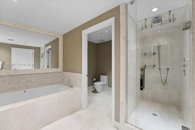 a bathroom with a bathtub shower and toilet