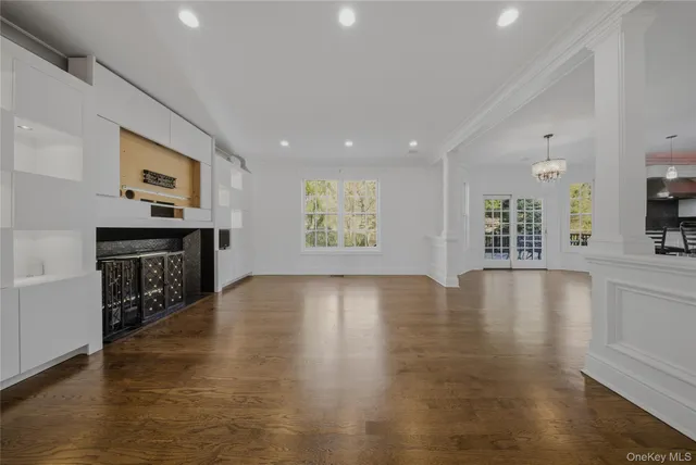 a view of an empty room with window and wooden floor