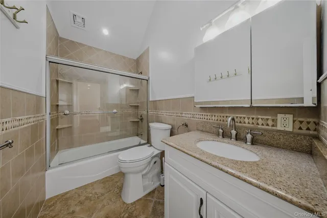 a bathroom with a granite countertop sink toilet and shower