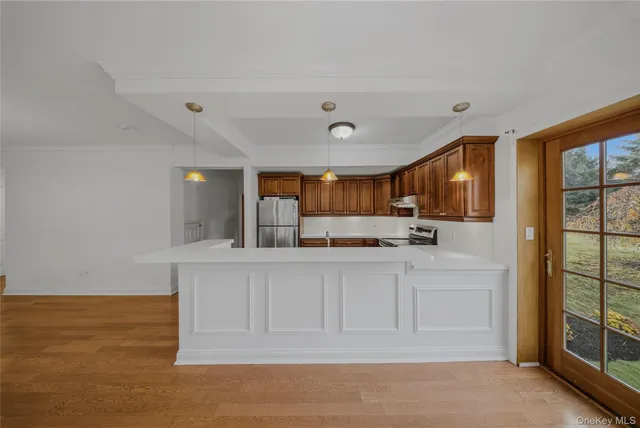 a kitchen with white cabinets and wooden floor