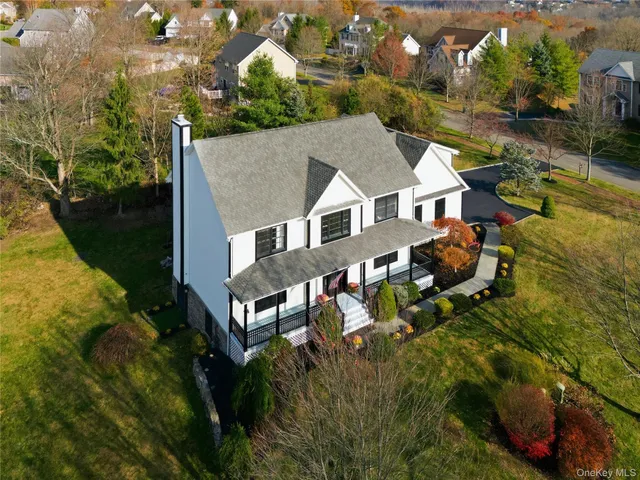 an aerial view of residential house with yard and outdoor seating