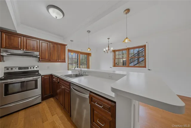 a kitchen with stainless steel appliances granite countertop a sink a stove and a wooden floors