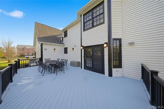 a view of a patio with table and chairs and a barbeque with wooden floor
