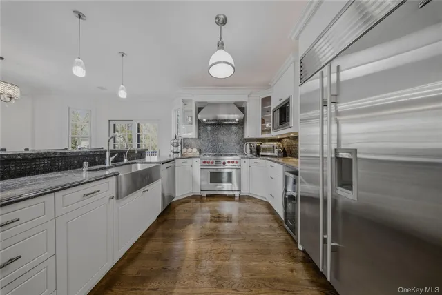 a large kitchen with cabinets a sink and stainless steel appliances