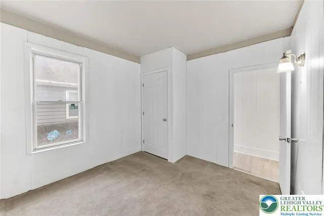 an empty room with windows and closet