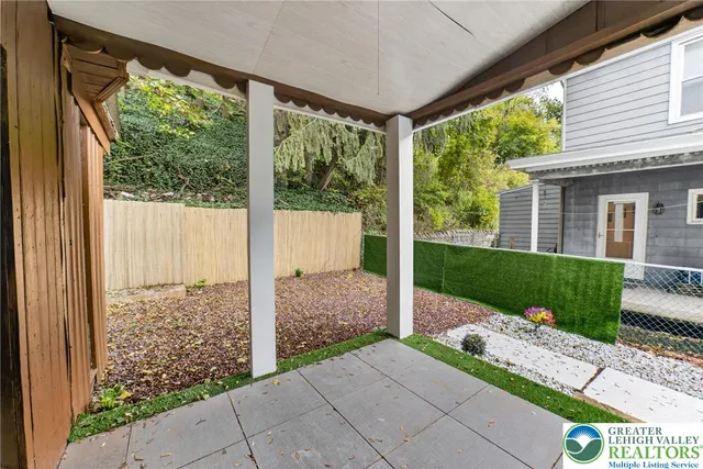 a view of backyard with large trees and plants