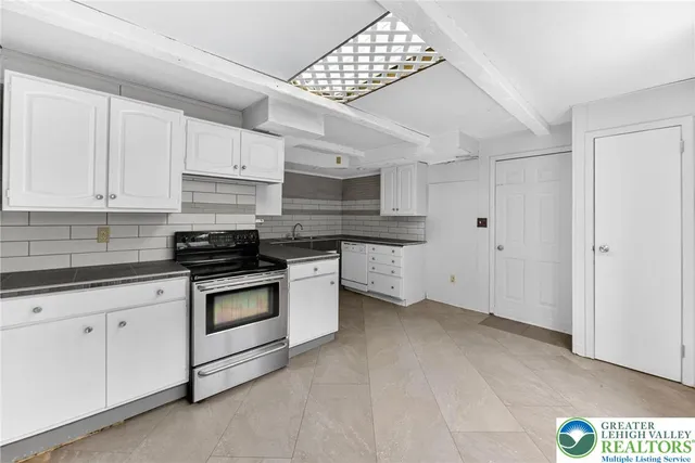 a kitchen with granite countertop white cabinets and stainless steel appliances