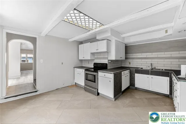 a kitchen with granite countertop white cabinets and white appliances