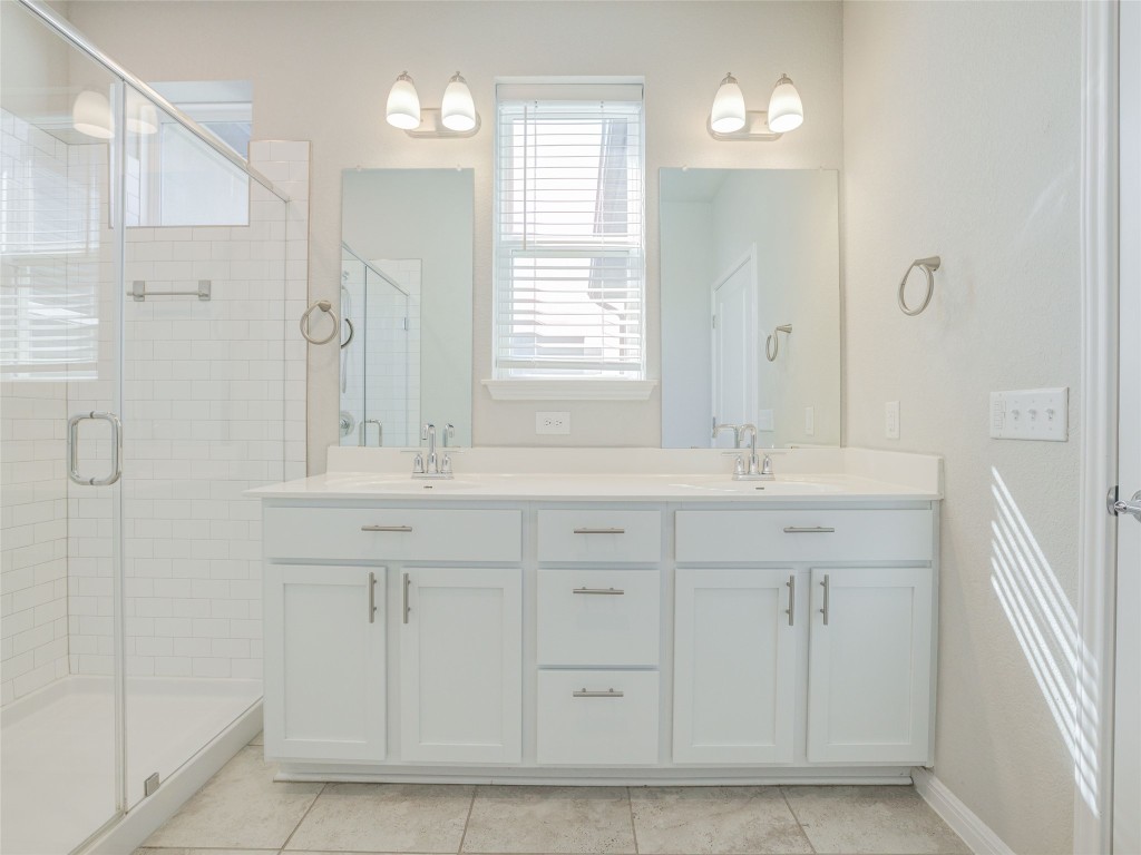 9015 Cattle Baron Path, Unit 502 Austin, TX 78747 - Photo 15 of 40 a bathroom with a double vanity sink mirror and next to a window