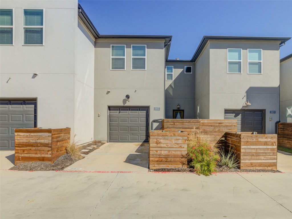 9015 Cattle Baron Path, Unit 502 Austin, TX 78747 - Photo 36 of 40 View of front of property featuring driveway, stucco siding, and an attached garage
