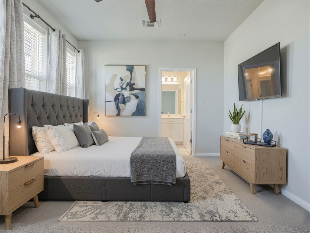 9015 Cattle Baron Path, Unit 502 Austin, TX 78747 - Photo 3 of 40 a bedroom with a large bed and a couch