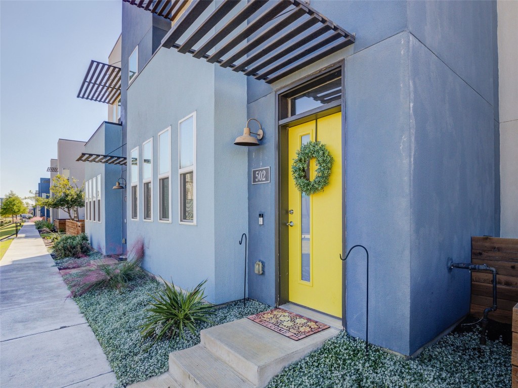 9015 Cattle Baron Path, Unit 502 Austin, TX 78747 - Photo 5 of 40 View of exterior entry with stucco siding and a pergola